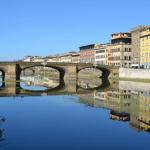 The mirror of the Arno River with the Ponte Santa Trinita.