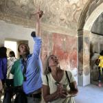 Giancarlo explains the ancient celiing frescos in a bath in Pompeii.